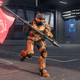 An orange spartan holds a red flag and runs on a steel floor in Halo Infinite multiplayer technical test